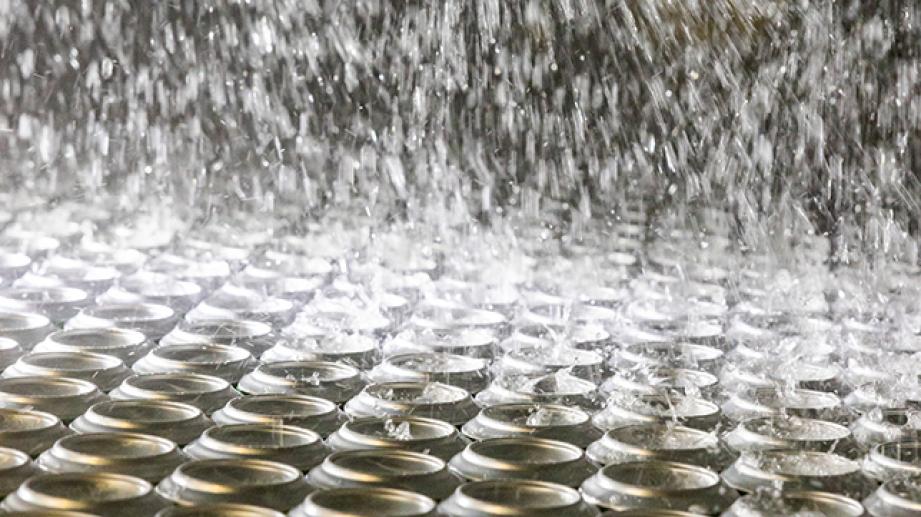 agua limpiando latas de cerveza