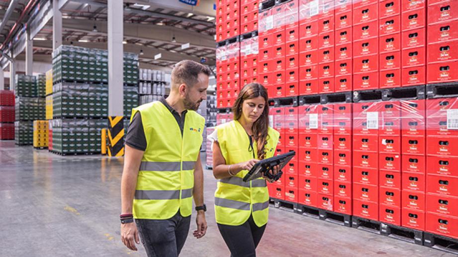 dues persones caminant per fàbrica de cervesa